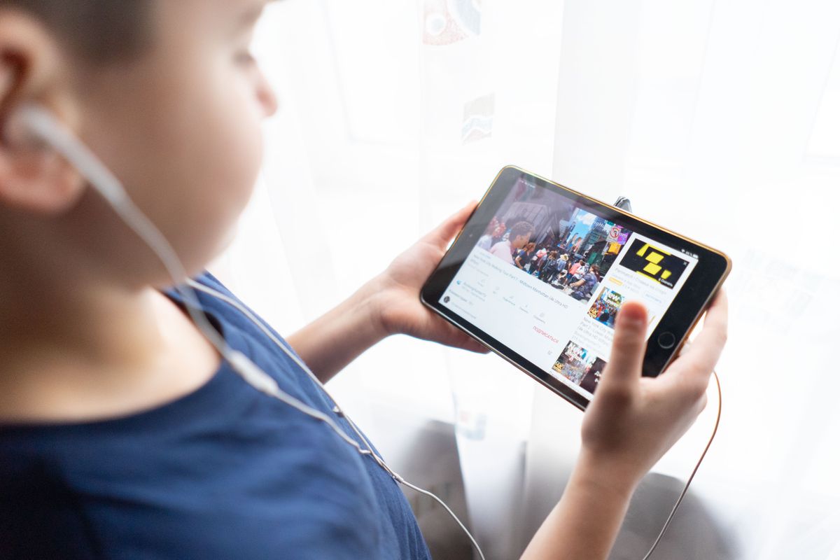Photo by Atlantic Ambience on Pexels Kind hält drinnen ein Tablet, schaut sich Videos mit Kopfhörern an und zeigt, wie Kinder die Technologie nutzen. - Foto von Atlantic Ambience auf Pexels