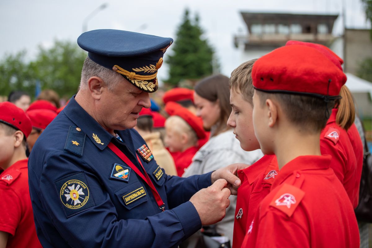 A Russian officer in uniform pinning a badge on a young recruit during an outdoor military ceremony. - Photo by Михаил Крамор on Pexels