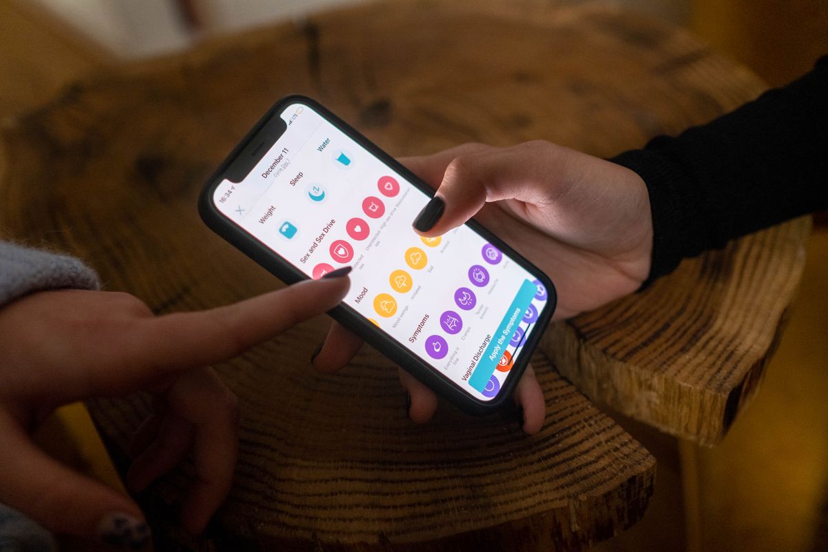 Primo piano delle mani che utilizzano un'app di monitoraggio della fertilità su uno smartphone in interni. - Foto di cottonbro studio su Pexels