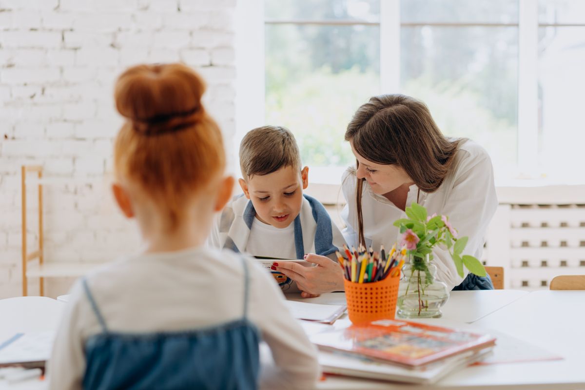 Engaging learning experience with a teacher and child exploring books and creativity in a bright classroom. - Photo by Mikhail Nilov on Pexels