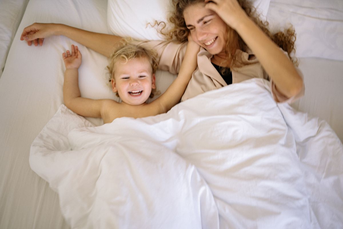 A joyful mother and child enjoying a playful moment together in bed. - Photo by Yan Krukau on Pexels