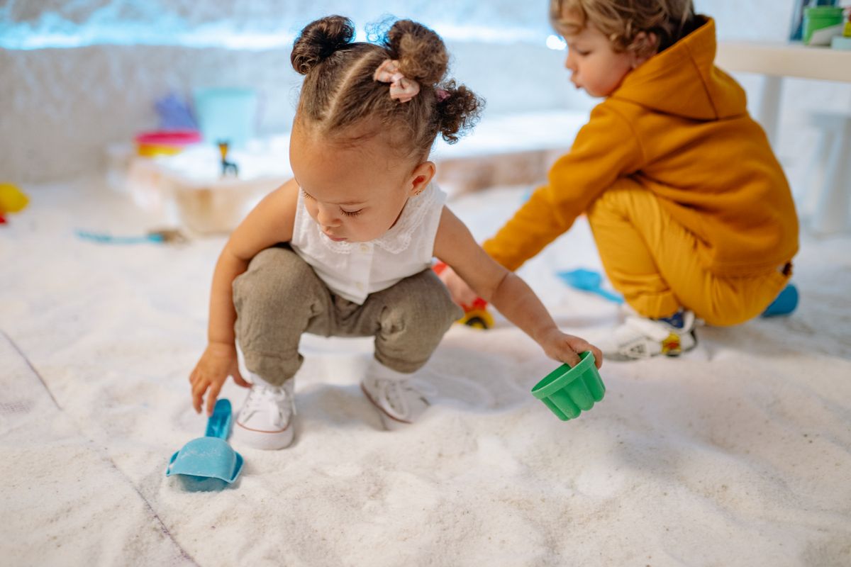 Two kids enjoying a fun indoor sand play session with colorful toys. - Photo by Yan Krukau on Pexels